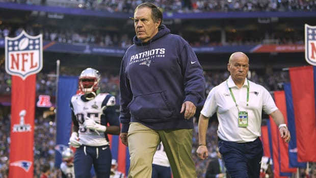 Bill Belichick walks onto the field before Super Bowl XLIX